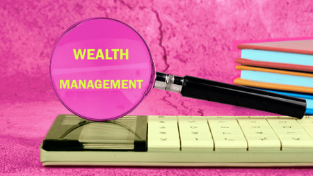 WEALTH MANAGEMENT words written through a magnifying glass on a crimson abstract backgroundの写真素材