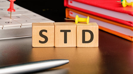 STD Sexually Transmitted Diseases. STD on wooden cubes in front of a black backgroundの写真素材
