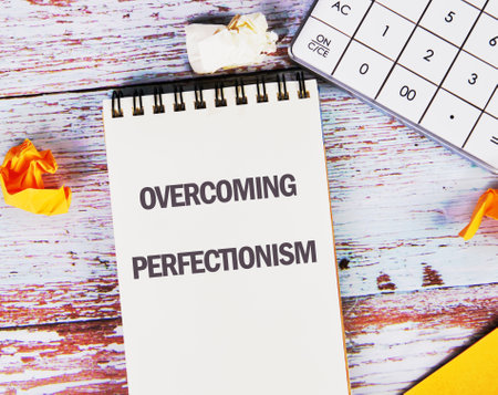 Business Overcoming perfectionism concept. Copy space. Concept words Overcoming perfectionism on a blank sheet of notepad located on old boardsの写真素材