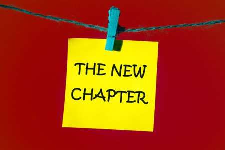 Conceptual the new chapter symbol. Copy space. The new chapter words written on a yellow sticker on a red backgroundの写真素材