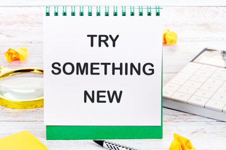 TRY SOMETHING NEW words on a blank sheet of a desktop notebookの写真素材