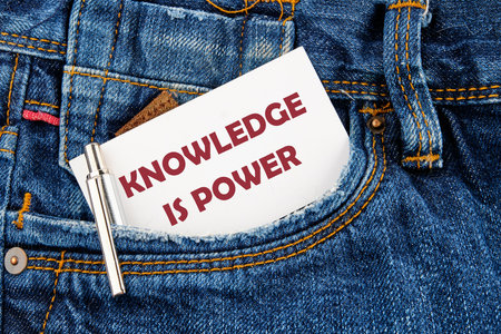 KNOWLEDGE IS POWER words on white card that appeared from the pocket of his jeansの写真素材