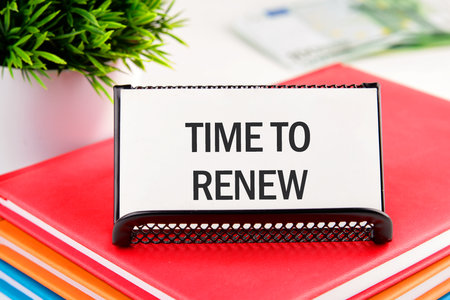 Conceptual time to renew concept. Copy space. Time to renew words written on a business card standing in a stand on notebooksの写真素材