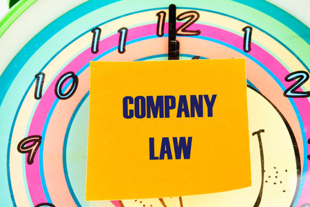 Business, accounting and real estate concept. COMPANY LAW written on the sticker on the background of the clock face with handsの写真素材