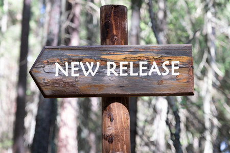 New Release written on a wooden signpost against a forest background