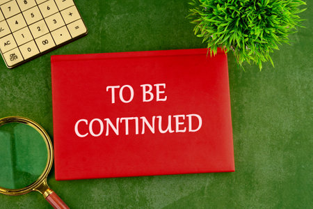 TO BE CONTINUED text written on the red book, business on a green saturated backgroundの写真素材