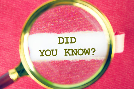 Business and Did you know concept. Copy space. DID YOU KNOW symbol on white paper through a magnifying glass under a torn piece of red paperの写真素材