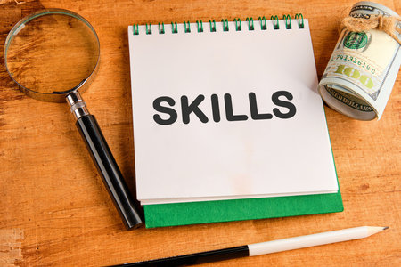 Upskilling and personal development concept. SKILLS words in a notebook on a papyrus backgroundの写真素材