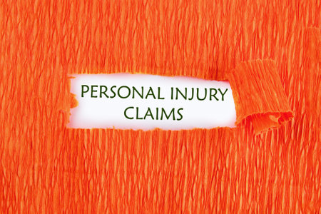Legal services of lawyers for medical malpractice claims. PERSONAL INJURY CLAIMS words conceptual phrase was found on a white background under a torn paperの写真素材