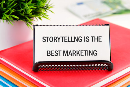 Copy space. Conceptual symbol STORYTELLING IS THE BEST MARKETING on a business card standing in a stand on notebooksの写真素材