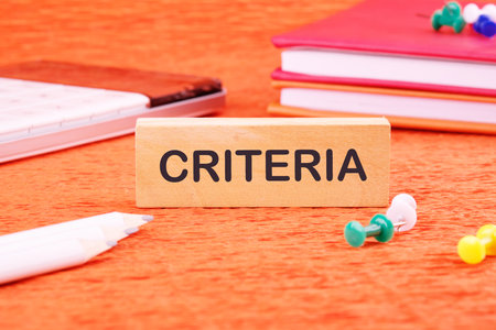 Criteria Controlling Follow Guidelines Conduct Concept. Criteria word on a wooden bar in front of an orange background, front viewの写真素材