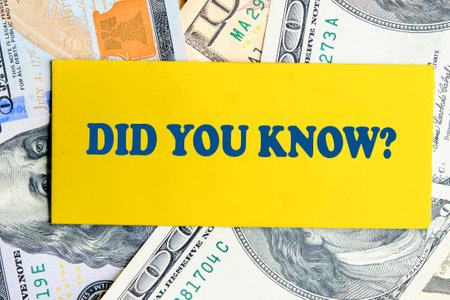 Business and Did you know concept. Copy space. DID YOU KNOW symbol on yellow paper against the background of American dollar billsの写真素材