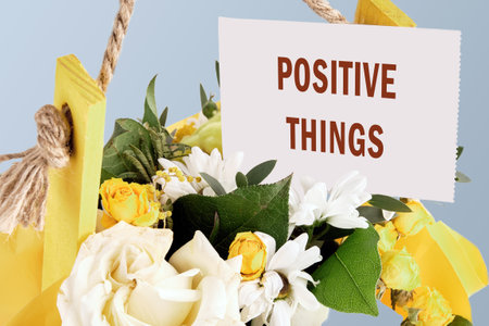 POSITIVE THINGS phrase on a white card in a basket with flowersの写真素材