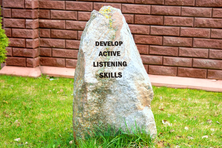 Business and Develop active listening skills concept. DEVELOP ACTIVE LISTENING SKILLS on a stone on...