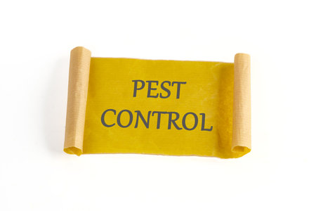 PEST CONTROL written on paper, a mustard-colored note on a white backgroundの写真素材