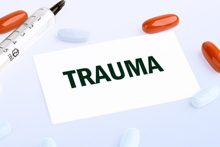 TRAUMA written on a white business card lying on a light background
