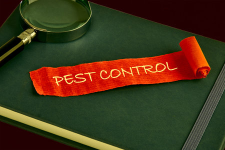 PEST CONTROL written on a piece of red paper on the background of a green business book, notebookの写真素材