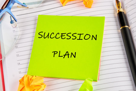 SUCCESSION PLAN word alphabet letters on a green sticker on the background of an open notebookの写真素材