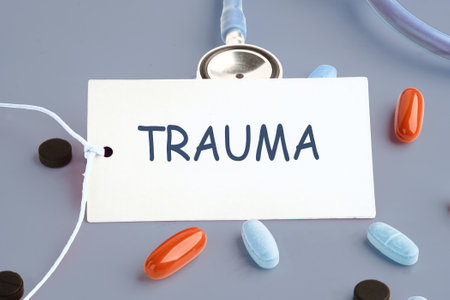 TRAUMA written on a white business card on a gray background next to the pills