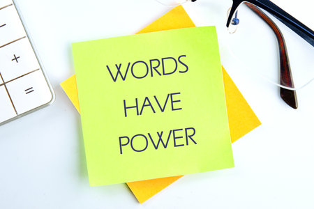 WORDS HAVE POWER TEXT written on a light green sticker on a light background.の写真素材