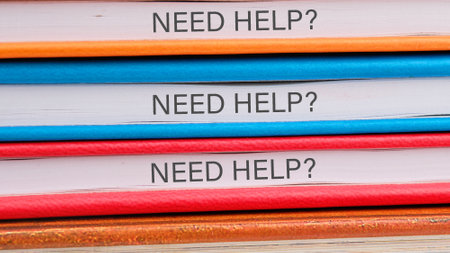 Business and Need Help concept. Copy space. Need Help symbol on the ends of notebooks lying on top...