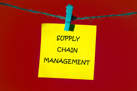 Business concept. SUPPLY CHAIN MANAGEMENT words on a piece of yellow sticker in front of a red background.の写真素材