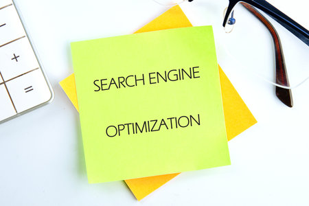 Business concept. Text SEARCH ENGINE OPTIMIZATION close-up, top view on a light green sticker.