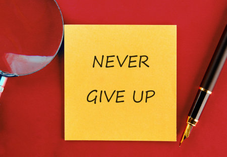 Business development challenge concept and effort success idea. Never give up written on a yellow...