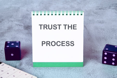 TRUST process, business concept. TRUST THE PROCESS words written on a desktop notebook, surrounded by a calculator and dice.の写真素材