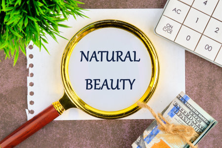 A serene arrangement featuring a magnifying glass over the words natural beauty, surrounded by greenery, a notebook, and currency, symbolizing appreciation for lives simple pleasures.の写真素材