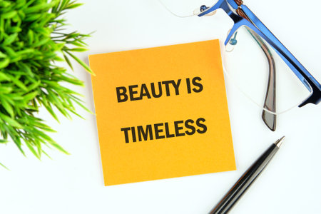 BEAUTY IS TIMELESS text written on a yellow sticker on a white background. Concept photo.の写真素材