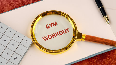 The concept of a healthy lifestyle. The words GYM WORKOUT through a magnifying glass on a blank...