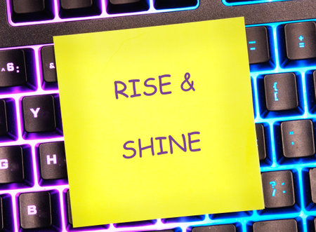 Growth Success Achievement Progress Concept. Words RISE AND SHINE written on a bright yellow sticker...