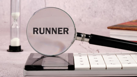 The word RUNNER through a magnifying glass surrounded by a calculator, hourglass and books, emphasizing the focus of the business and strategy.の写真素材