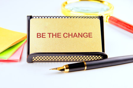 Words BE THE CHANGE on a gold business card.の写真素材