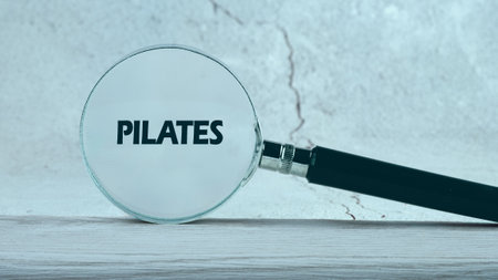 Exercise and fitness concept. PILATES word through a magnifying glass on an abstract background.の写真素材
