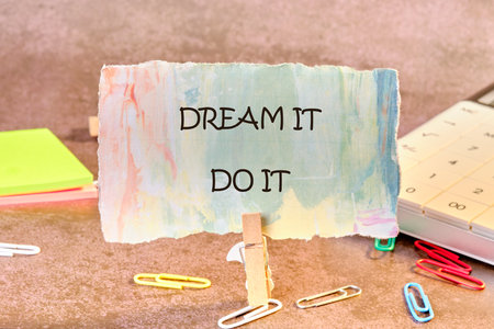 Motivational words DREAM IT, DO IT written on paper, fixed in a clothespin.の写真素材