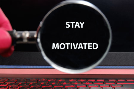 Business, support, motivation, psychological concept. STAY MOTIVATED through a magnifying glass on a...