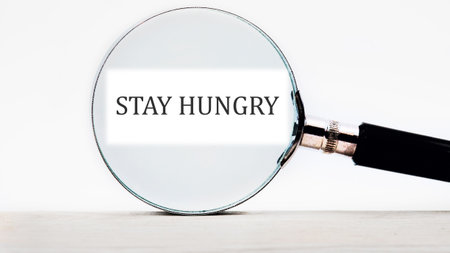 Concept Phase STAY HUNGRY focused through a magnifying glass.