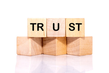 The concept word TRUST is assembled from wooden cubes. Investment based on trust concept.の写真素材