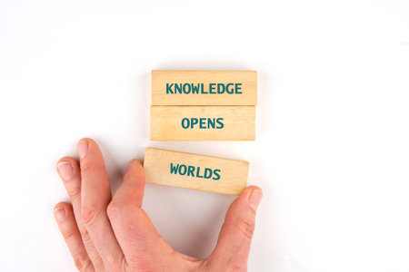 Academic education learning concept. Words KNOWLEDGE OPENS WORLDS made from blocks by hand on a...