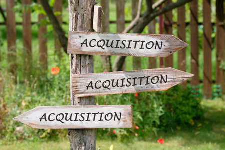 Copy space. Attraction of investments concept. ACQUISITION word written on Wooden signs indicating...