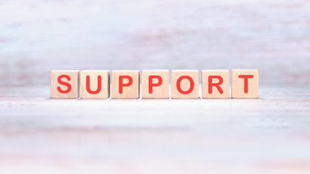 The concept word SUPPORT is made of wooden cubes on a light background. Business and SUPPORT...