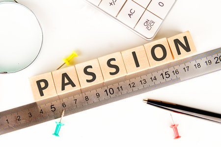 The concept word PASSION is assembled from wooden cubes on a white surface. Business mission vision...