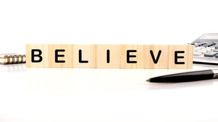 The concept word BELIEVE has been collected of wooden cubes on a white background. Business believe...