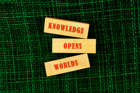 Education,student,university concept. KNOWLEDGE OPENS WORLDS made of wooden blocks on fabric...
