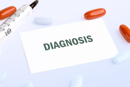 Medicines, including pills and a syringe, are arranged around a card that reads DIAGNOSIS against a plain white backdrop. It speaks to finding answers about health issues.の写真素材