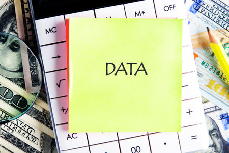 DATA word written on the sticker on the calculator on the background of banknotes. Business strategy success concept.の写真素材