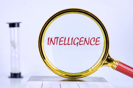 INTELLIGENCE text was revealed through a magnifying glass on a light background that was on the calculator. Futuristic Concept of Intelligence, science and mind.の写真素材