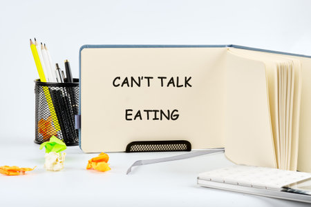 A workspace features a message board stating Cant Talk Eating alongside a container of stationery, emphasizing a creative, engaging atmosphere filled with vibrant colors.の写真素材